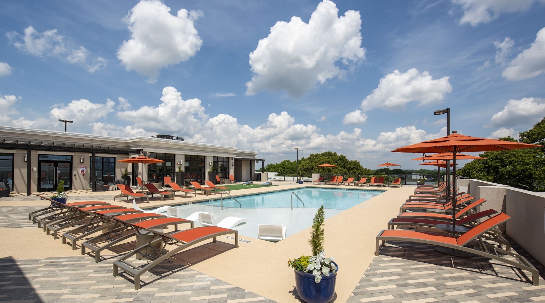 a swimming pool on a roof top with chairs