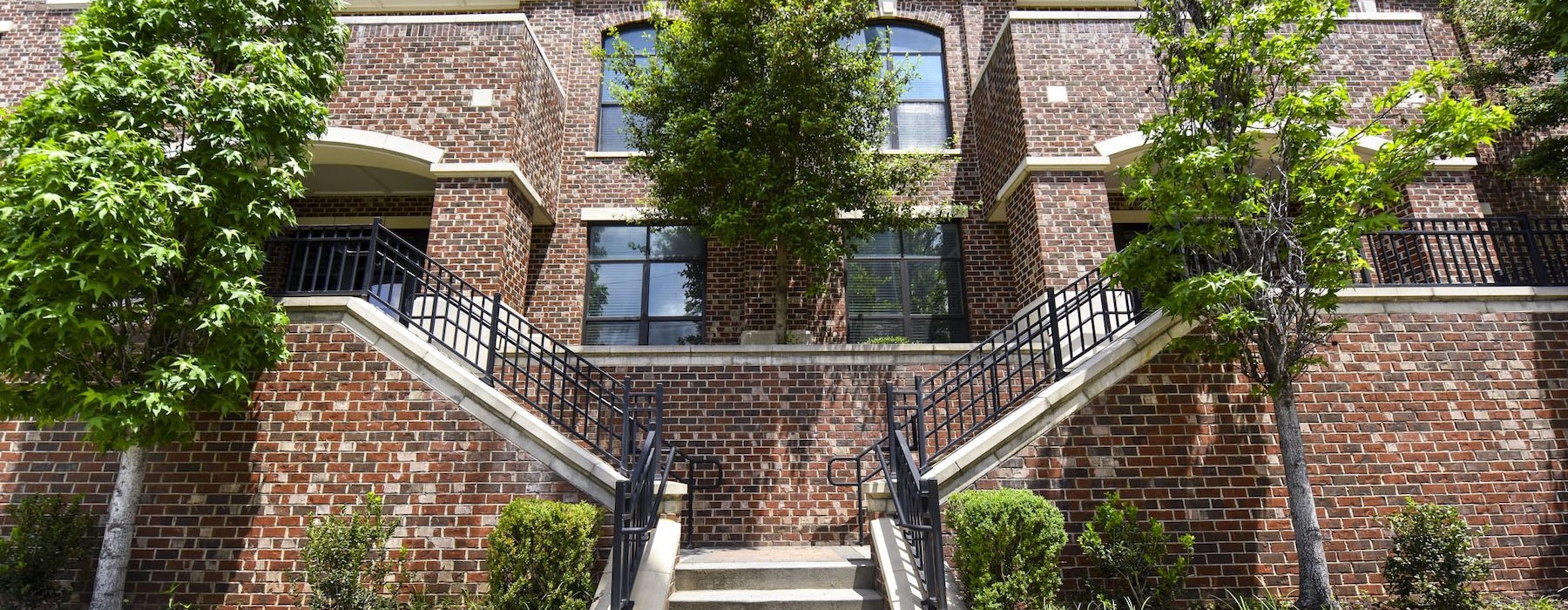 a brick building with trees and stairs